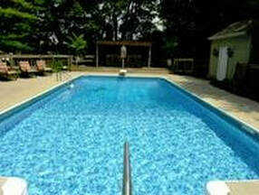 Picture of a clean blue rectangular pool in Little Rock Ar looking from the shallow end toward the diving board end